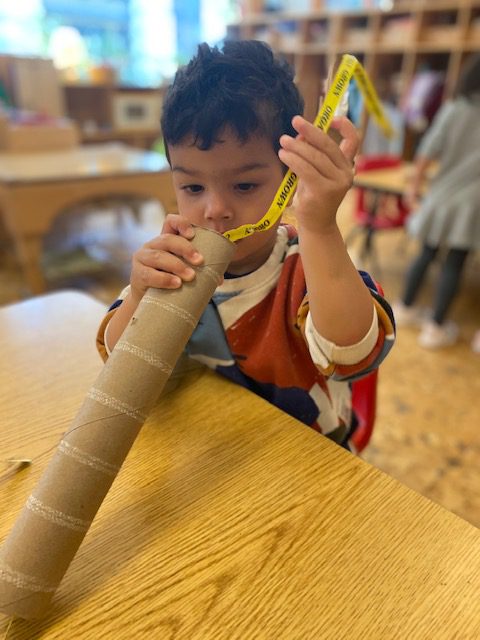 A child stuffing materials into a tube